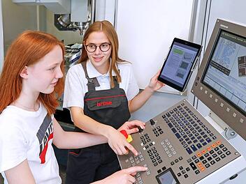 Vor vier Jahren hat Eva Dohles (rechts) selbst am Girls' Day bei Brose teilgenommen. Jetzt absolviert die 17-J&auml;hrige eine Ausbildung zur Werkzeugmechanikerin und erkl&auml;rte der Gymnasiastin Emily Jung (14) das Programmieren einer CNC-Fr&auml;smaschine.Foto: Brose