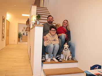 Manuel Betz mit seiner Frau Katharina, den Kindern Greta und Jakob sowie Familienhund Dodge auf der Treppe ihres neugebauten Hauses im Baugebiet Völkersleier. Foto: Ralf Ruppert