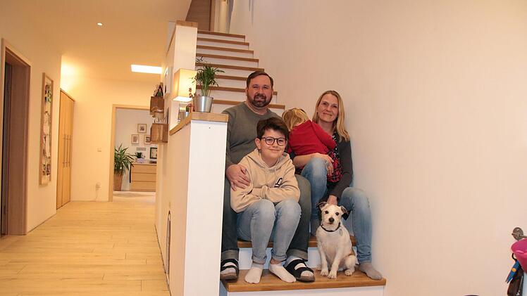 Manuel Betz mit seiner Frau Katharina, den Kindern Greta und Jakob sowie Familienhund Dodge auf der Treppe ihres neugebauten Hauses im Baugebiet Völkersleier. Foto: Ralf Ruppert