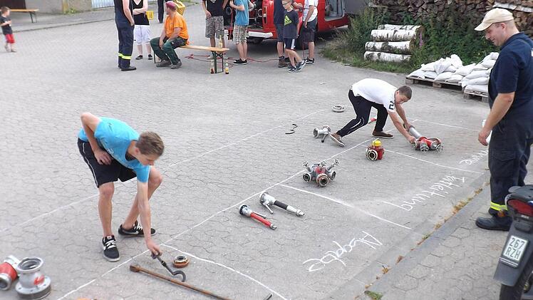 Wie gehören die wasserführenden Armaturen, Kupplungen und das sonstige Zubehör zusammen? Bastian Eck und Lukas Stappenbacher im Wettbewerb, Maschinist Martin Eck steht zur Seite.