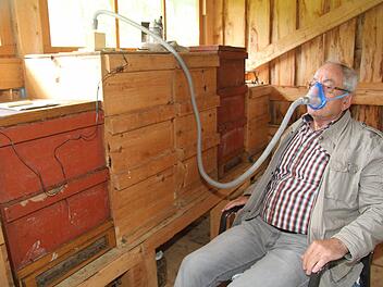 Imker Martin Pletl aus Kasendorf demonstriert das Api Air Inhalationsgerät. In dem kleinen Kästchen links oben sitzt ein Ventilator, der mit einem Pollenfilter abgeschirmt wird. Das Gerät wird einfach auf die Bienenbeute aufgesetzt. Foto: Sonja Adam