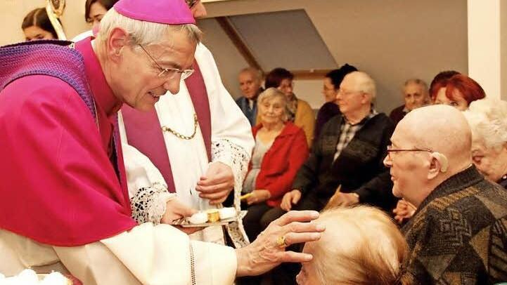 Die 94-jährige Katharina Schneider empfängt von Erzbischof Ludwig Schick die Krankensalbung. Foto: Johanna Blum