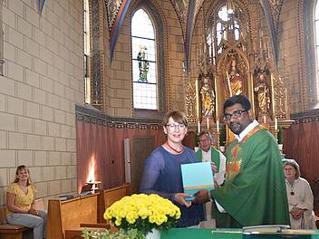 Dankesworte und Präsentübergabe bei der Verabschiedung von Pater Thomas in Neukenroth. Links sitzend, Bettina Rubel, vorne stehend Sabine Scherbel (Pfarrgemeinderatsvorsitzende), Pater Thomas Pramod, dahinter Mitte Pfarrer Hans Michael Dinkel.  Foto: K.- H. Hofmann