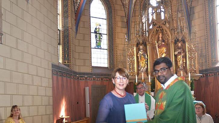 Dankesworte und Präsentübergabe bei der Verabschiedung von Pater Thomas in Neukenroth. Links sitzend, Bettina Rubel, vorne stehend Sabine Scherbel (Pfarrgemeinderatsvorsitzende), Pater Thomas Pramod, dahinter Mitte Pfarrer Hans Michael Dinkel.  Foto: K.- H. Hofmann