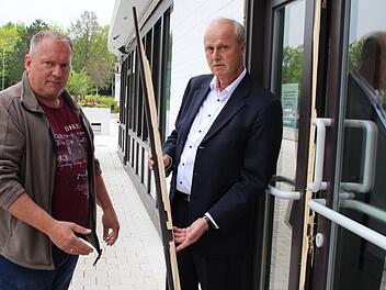 H&ouml;chstadts B&uuml;rgermeister Gerald Brehm (rechts) und Betriebsleiter Hans-Peter Philipp mit einem Teil der aufgebrochenen T&uuml;r zur W&auml;rmehalle des Freibads. Foto: Andreas Dorsch