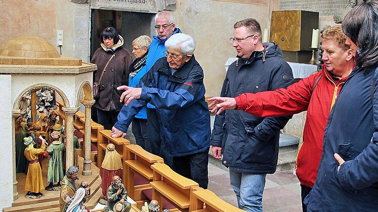 Mehr als 50 Jahre lang kümmerte sich Toni Hiller (Bildmitte) um die Krippe in  der Pfarrkirche St. Maria Magdalena, bis Christian Schmitt seine Arbeit  übernahm. Beim Besuch der Krippenfreunde aus Fulda erklärte Hiller den  Gästen die Figuren in der Schunterkapelle. Foto: Dieter Britz       ----