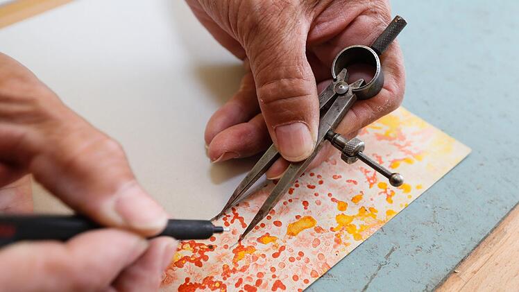 Mit dem Zirkel wird der Zuschnitt des Einbandmaterials gemessen.  Foto: Matthias Hoch