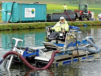 Von einem Amphibienboot aus wird der Schlamm vom Grund des Klärteichs absaugt.  Foto: Dieter Hübner