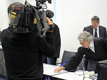 Verteidiger Klaus Bernsmann serviert dem Angeklagten ein Glas Wasser.   Foto: Peter Groscurth