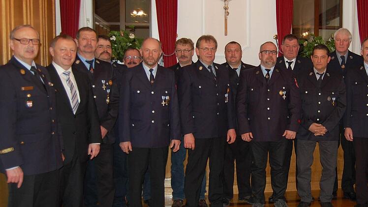 Landrat Thomas Bold und weitere Verantwortliche zusammen mit den geehrten Feuerwehrleuten.