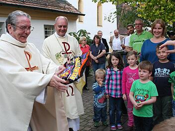 Für sein Willkommensständchen bedankte sich Pater Gabriel (l.) bei den Kindergartenkindern mit Süßigkeiten. Foto: Evi Seeger