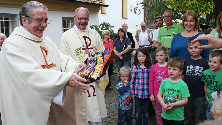 Für sein Willkommensständchen bedankte sich Pater Gabriel (l.) bei den Kindergartenkindern mit Süßigkeiten. Foto: Evi Seeger