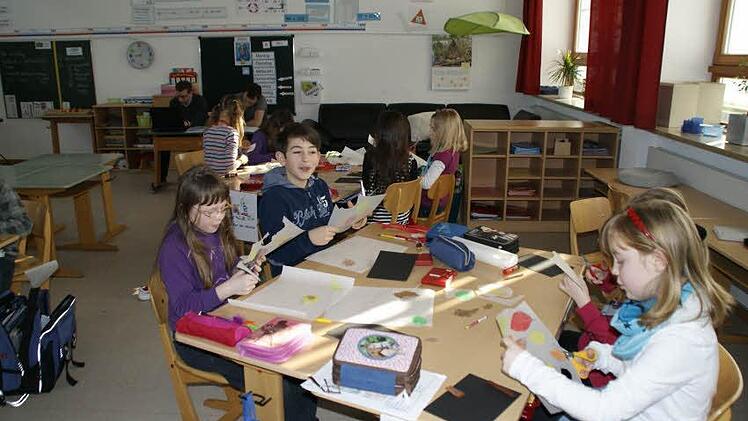 Nach dem Tag im Wald bewies die 3a der Grundschule Sylbach, was sie gelernt hat. Unter anderem entstand eine Waldcollage. Die beiden Studenten Sebastian und Philipp (hinten) gehörten in der vergangenen Woche ganz selbstverständlich zum Unterrichtsalltag der Grundschüler. Foto: sw
