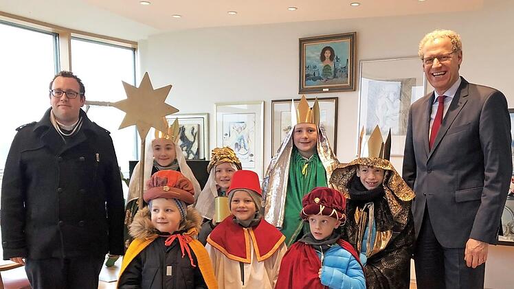 Kaplan Tobias Fehn (l.) begleitete die Sternsinger zu B&uuml;rgermeister German Hacker. Foto: privat