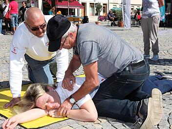 Alois Kreml (rechts) bringt BRK-Mitarbeiterin Simone Gilley in die stabile Seitenlage. Rettungsassistent Harald Krumpholz erkl&auml;rt die dazu notwendigen Handgriffe. Foto: Michael Will/BRK