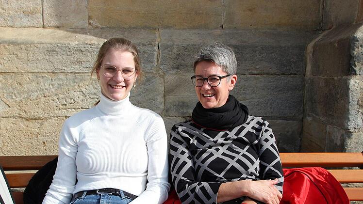 Sina Heß (links) und Jessica Heß auf einer Bank vor den Arkaden