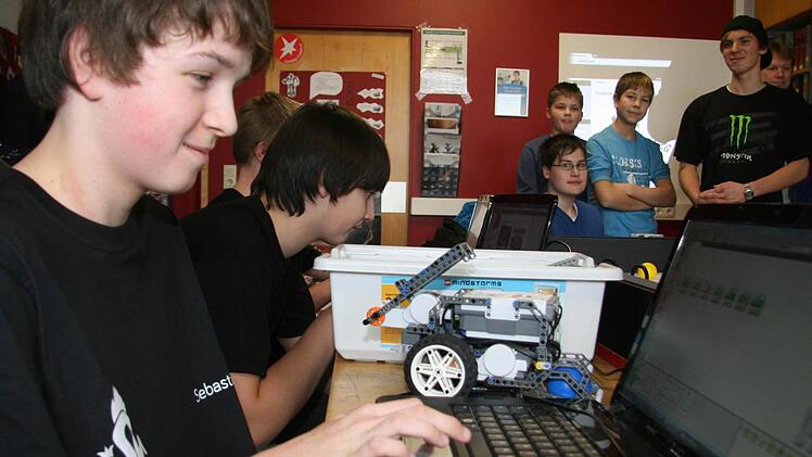 Sebastian Scherbel (14) programmiert am Laptop, was der Roboter auf dem Spielfeld machen soll.