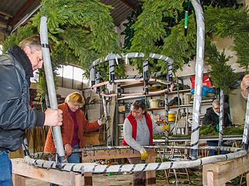 Sieglinde Escher (zweite von links) packt seit 40 Jahren bei den Garten- und Blumenfreunden tatkräftig mit an. Gemeinsam mit (von links) Vorsitzendem Gerhard Albert und Margitta Fleischmann hebt sie die Osterkrone hoch, die einen Durchmesser von 3,5 Metern hat.  Foto: Archiv/Jürgen Gärtner