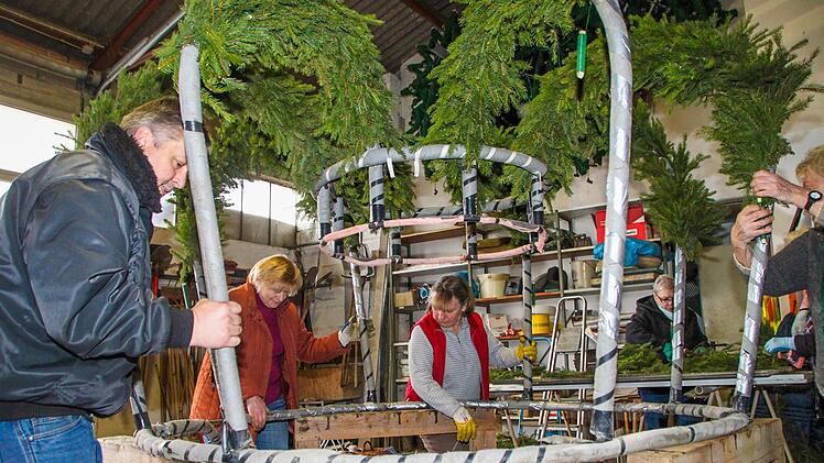 Sieglinde Escher (zweite von links) packt seit 40 Jahren bei den Garten- und Blumenfreunden tatkräftig mit an. Gemeinsam mit (von links) Vorsitzendem Gerhard Albert und Margitta Fleischmann hebt sie die Osterkrone hoch, die einen Durchmesser von 3,5 Metern hat.  Foto: Archiv/Jürgen Gärtner