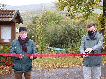 Stellvertretender Landra Gotthard Schlereth  (links) und Hammelburgs Bürgermeister Armin Warmuth gaben den neuen Wanderweg "Kalk und KulTOUR - Erleben in der Natur"  in Obereschenbach offiziell frei, indem sie ein rotes Band durchschnitten. Foto: Hilmar Ruppert