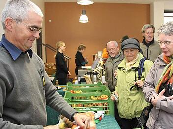 Claus Schmitt packt einer Kundin Äpfel ein: Der monatliche Bauernmarkt soll erhalten bleiben.  Foto: Archiv/Markus Reeh