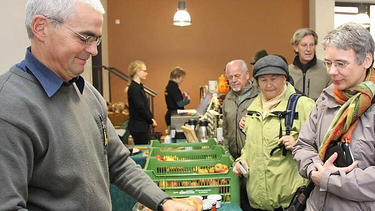 Claus Schmitt packt einer Kundin Äpfel ein: Der monatliche Bauernmarkt soll erhalten bleiben.  Foto: Archiv/Markus Reeh