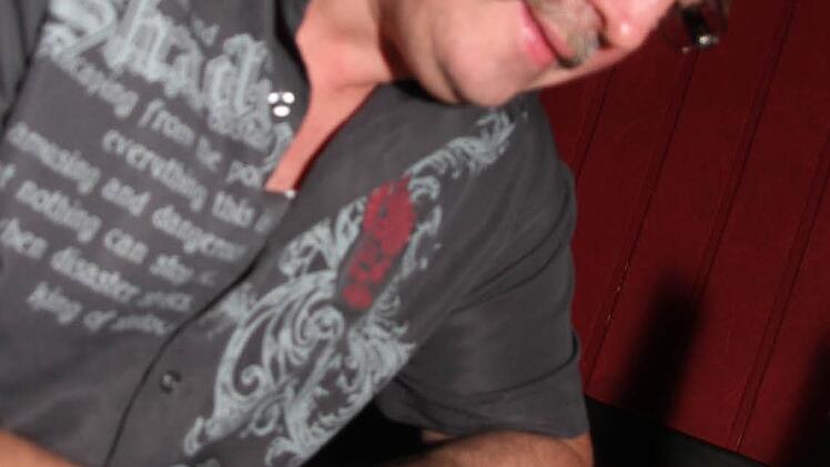 Gerd Zink füllt einen Zettel für die Er-sucht-Sie-Pinwand aus.