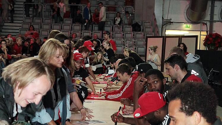 Gut gelaunt schreiben die Spieler Autogramme.