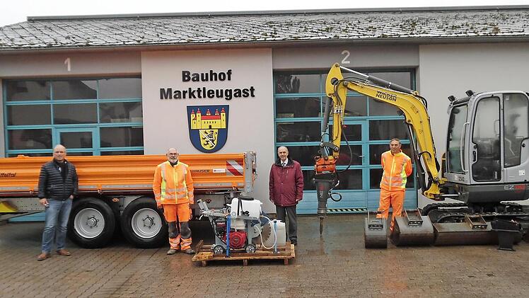 Das Bild zeigt den neuen Anhänger und auf der Palette einige Gerätschaften sowie den Kleinbagger. Außerdem im Bild sind (von links) Roland Tiroch vom Bauamt, Bauhofmitarbeiter Udo Hübschmann, Bürgermeister Franz Uome und Bauhofleiter Fredi Ott. Foto: Klaus-Peter Wulf