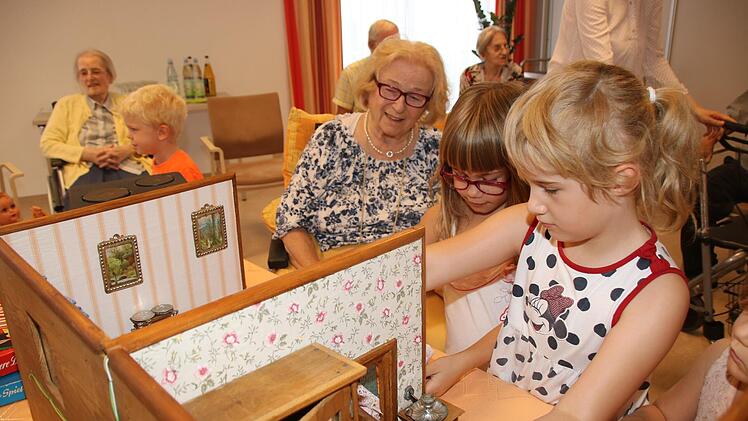 Attraktion bei der gemeinsamen Spielstunde: Die alte Puppenstube begeistert Seniorin Christel Popp ebenso wie Sophie Ciobanu und Xenia Heuschmann. Fotos: Dagmar Besand