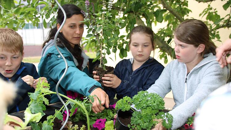 Eunike Schu von der Kulmbacher Urban-Gardening-Gruppe bepflanzt mit den Kindern der Grundschule Melkendorfas erste Hochbeet.Dagmar Besand