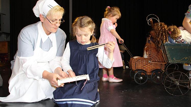 Bei der Jubiläumsfeier des Kindergartens Marienschule wurde gezeigt, mit welchen Dingen Jungs und Mädchen vor 175 Jahren gespielt haben - und wie die Erzieherinnen damals gekleidet waren. Foto: Oliver Schmidt