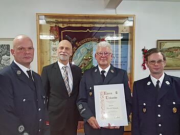 Stellvertretender Kommandant Christoph Kreps (links), Oberbürgermeister Kay Blankenburg und Kommandant Matthias Mahlmeister (rechts) überreichten Harald Blasek die Ernennungsurkunde zum Ehrenmitglied und gratulierten. Foto: Bernd Czelustek