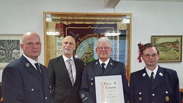 Stellvertretender Kommandant Christoph Kreps (links), Oberbürgermeister Kay Blankenburg und Kommandant Matthias Mahlmeister (rechts) überreichten Harald Blasek die Ernennungsurkunde zum Ehrenmitglied und gratulierten. Foto: Bernd Czelustek