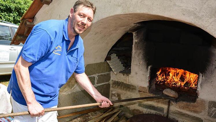 Matthias Fischer hatte beim Spielefest im Aschacher Schlosspark des wärmsten Arbeitsplatz: Er sorgte für frisch gebackenes Brot und Plootz. Foto: Björn Hein