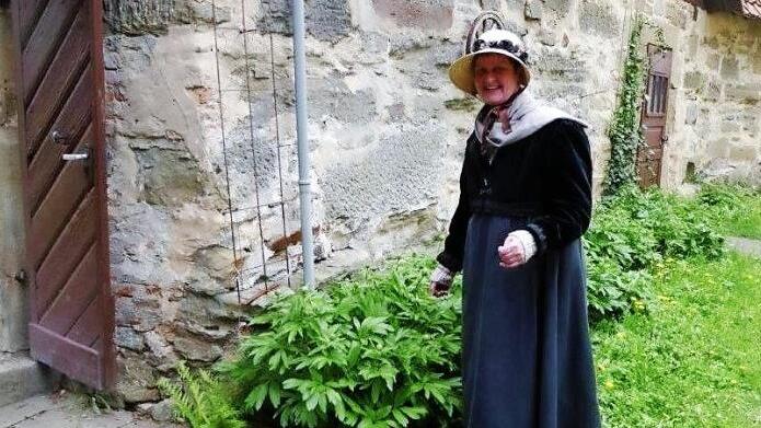 Hedda Hanft als Therese Schmidt im Empire-Barockkleid kontrolliert während der Kostümführung auch das Wachstum im Garten.  Fotos: Volker Gundel