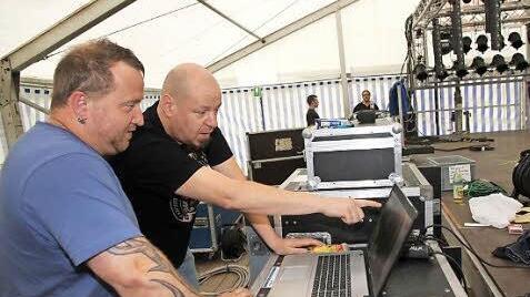 Matthias Sitzmann (hinten) aus Neuses, Gitarrist von Stahlzeit, spricht mit Pyrotechniker Colt Plomer die letzten Details der Bühnenshow durch.