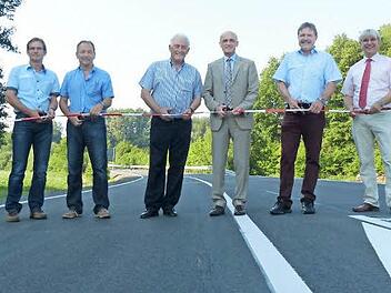 Sie durchtrennten das Band und gaben den Verkehr auf der sanierten Kreisstraße offiziell frei, von links: Hubert Schramm (Tiefbauverwaltung des Kreises), Karl Reuter und Armin Stolz (beide von der Baufirma), Landrat Wilhelm Schneider, Alfons Schanz (Leiter Tiefbauverwaltung) sowie Manfred Rott (Staatliches Bauamt).