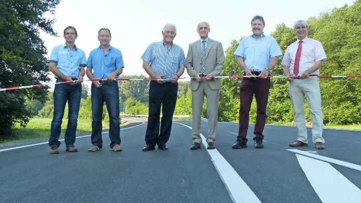 Sie durchtrennten das Band und gaben den Verkehr auf der sanierten Kreisstraße offiziell frei, von links: Hubert Schramm (Tiefbauverwaltung des Kreises), Karl Reuter und Armin Stolz (beide von der Baufirma), Landrat Wilhelm Schneider, Alfons Schanz (Leiter Tiefbauverwaltung) sowie Manfred Rott (Staatliches Bauamt).