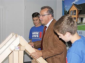 Stellvertretender Landrat Emil Müller begutachtet das Zimmerwerk der Praktikanten Joshua Kühnlein (vorn) und Tobias Frischat.Fotos: Gerd Schaar