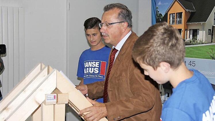 Stellvertretender Landrat Emil Müller begutachtet das Zimmerwerk der Praktikanten Joshua Kühnlein (vorn) und Tobias Frischat.Fotos: Gerd Schaar