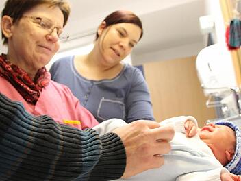 Hebamme Gabriela Kruppa wickelt mit Mutter Julia Seydlitz den zwei Tage alten Fabian.  Foto: Benedikt Borst