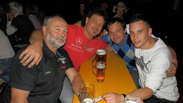 Vier Trucker feiern zusammen. Die Brummifahrer kommen auch aus Österreich nach Geiselwind angereist. Foto: Rainer Fritsch