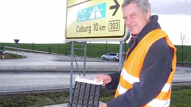 Jürgen Woll, Leiter der Servicestelle Kronach des Staatlichen Bauamtes Bamberg, zeigt die Bitumen-Armierung, mit der die Einfahrten zur Bundesstraße 303 bei Ebersdorf stabilisiert werden sollen. Foto: Berthold Köhler