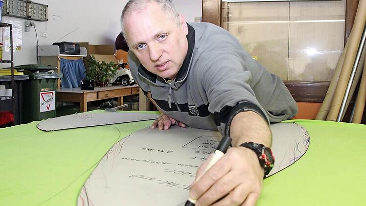 Mitarbeiter Rainer Popp schneidet den Bezug für Sitzsäcke zu.
