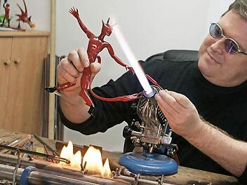 Olaf Schönherr bei seiner Arbeit vor der Flamme, wo die Glasfigur eines roten Teufels zur Vollendung kommt. Foto: Günther Geiling