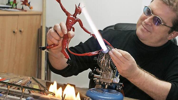 Olaf Schönherr bei seiner Arbeit vor der Flamme, wo die Glasfigur eines roten Teufels zur Vollendung kommt. Foto: Günther Geiling