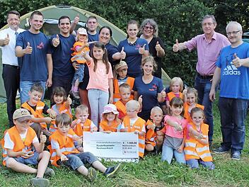 Ihre Warnwesten weisen sie als Kinderfeuerwehr aus. Mit den Kindern freuen sich Kommandant Erwin Bergner (r.), Bürgermeister Karsten Fischkal (l.) und die Betreuer. Alexander Nothaft vom Konzern N-Ergie (2. v. r.) hatte eine Spende im Gepäck. Foto: Evi Seeger