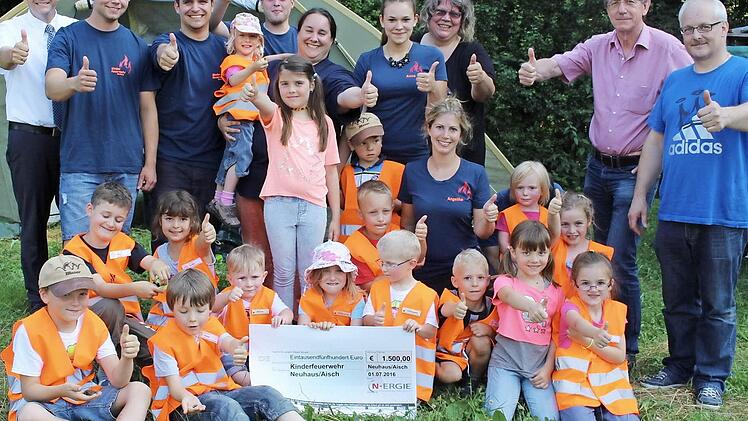 Ihre Warnwesten weisen sie als Kinderfeuerwehr aus. Mit den Kindern freuen sich Kommandant Erwin Bergner (r.), Bürgermeister Karsten Fischkal (l.) und die Betreuer. Alexander Nothaft vom Konzern N-Ergie (2. v. r.) hatte eine Spende im Gepäck. Foto: Evi Seeger