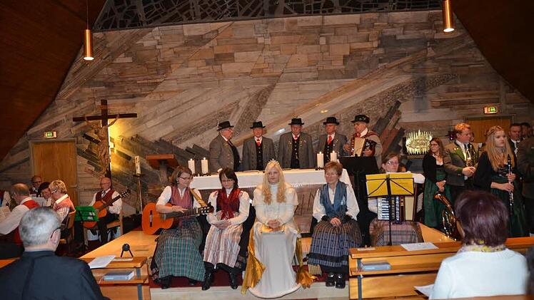 Sie ließen mit ihren musikalischen Gebeten die Reise zur Krippe zum Klangerlebnis werden. Links die Rothenkirchener Stubenmusik, die Haache Stöckraache (hinten Mitte), die Kronicher Maala (vorne) mit Christkind Melissa Dörfer und die Blaskapelle Neufang (rechts). Foto: Karl-Heinz Hofmann